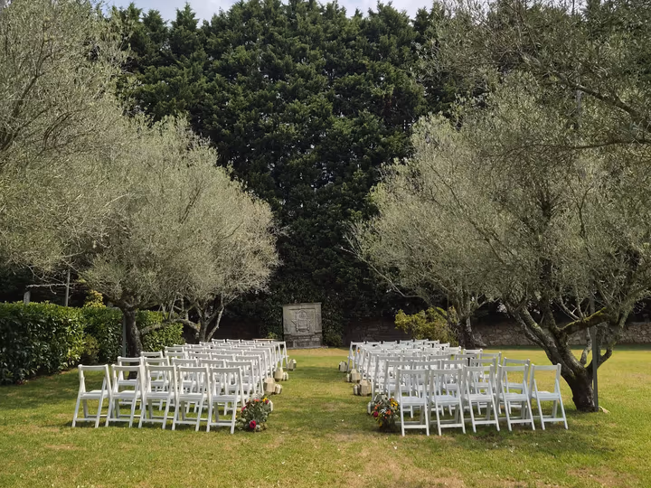 Sillas blancas para la ceremonia civil entre los olivos del jardín de Quinta do Ramo