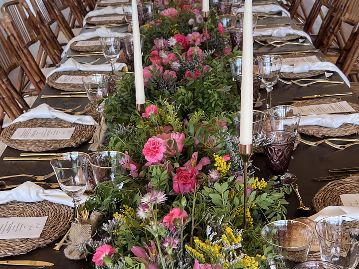 Mesa imperial vestida con flores silvestres y velas en el salón de Finca La Atlántida