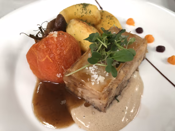Cochinillo prensado con patatas torneadas y tomate glaseado