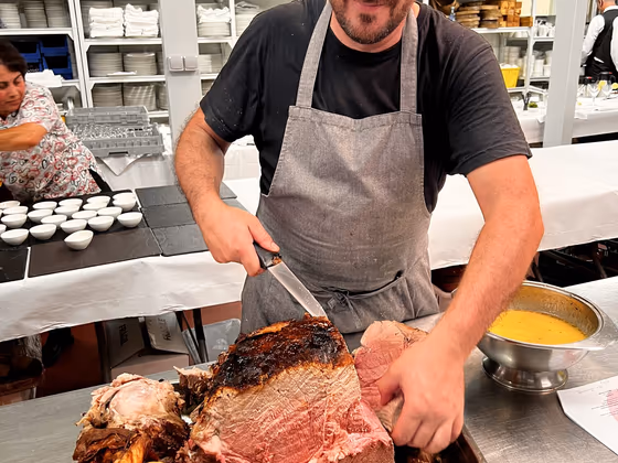 Cocinero de Sens trinchando la pierna de ternera asada en sala